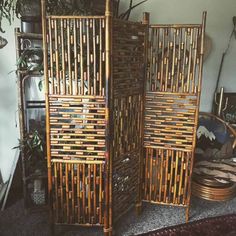 two tall bamboo screens sitting next to each other on a rug in front of a window