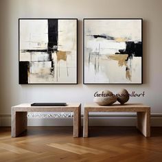 two abstract paintings hang on the wall above a coffee table in a modern living room