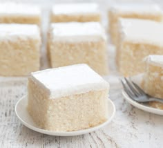 several pieces of cake sitting on top of plates next to a fork and spoons