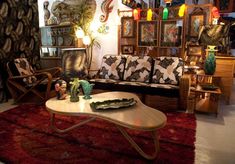 a living room filled with furniture and pictures on the wall next to a red rug