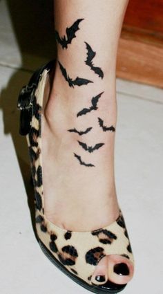 a woman's foot with bats on it and the caption reads, tattoo by tom raven