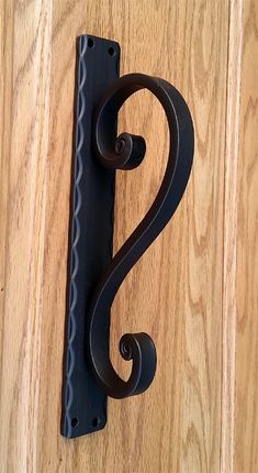 a door handle on a wooden door with the letter s in black painted on it