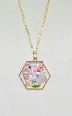 Lovely coastal/pressed flower resin pendant necklace. Made on a 16 inch clavicle, gold tone chain.  All jewelry purchases come beautifully gift wrapped at no additional cost. Complementary thank you goodie with each purchase as a token of our appreciation 1. Avoid Chemicals: Remove jewelry before using household cleaners, perfumes, or lotions. 2. Proper Storage: Store in a soft pouch or lined jewelry box to prevent scratches and tarnishing. 3. Avoid Water: Don't wear in chlorinated or saltwater Gift Shell Necklace With Lobster Clasp, Handmade Flower Shell Necklace Gift, Pressed Flower Resin, Pressed Flower Necklace, Resin Pendant Necklace, Necklace Resin, Flower Resin, Shell Necklace, Household Cleaners