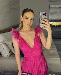 a woman in a pink dress taking a selfie