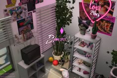 a pink heart shaped neon sign sitting on top of a shelf next to a potted plant