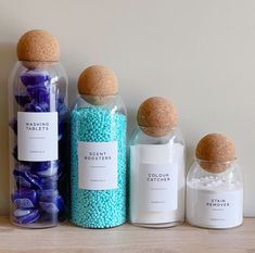 three bottles with different types of candies in them sitting on a shelf next to each other