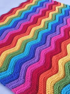 a multicolored crocheted blanket on a white surface