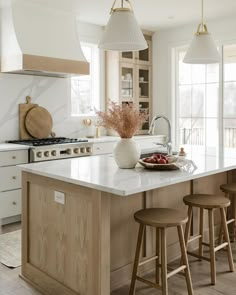 a kitchen island with three stools next to it