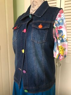 Blue denim vest enhanced with gorgeous sweet multicoloured plastic vintage buttons.  Condition is excellent.  Size L Measurements Blue Button-up Vest With Buttons, Blue Denim Vest With Buttons For Spring, Spring Blue Denim Vest With Buttons, Trendy Blue Denim Vest With Buttons, Blue Button-up Denim Vest, Button-up Blue Denim Vest, Button-up Blue Denim Vest With Buttons, Trendy Blue Vest With Button Closure, Blue Button-up Vest With Button Closure