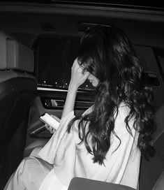 a woman sitting in the back seat of a car