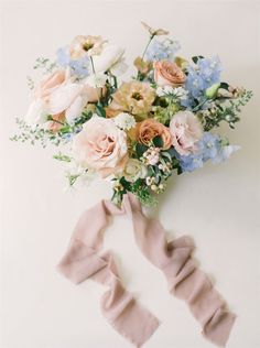 a bouquet of flowers on top of a white table next to a pair of pink socks