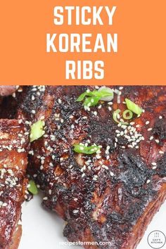 sticky korean ribs on a white plate with sesame seeds and green onion sprinkles