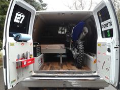 the back end of a white van with an atv in it's cargo area