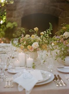 the table is set with flowers and candles