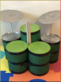 there are many green cups with lids on the table and one has two straws in it