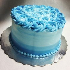 a blue and white cake with swirls on it sitting on a glass platter