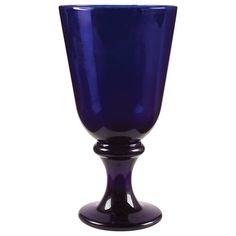 a blue glass vase sitting on top of a white table