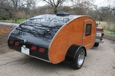 an enclosed trailer is parked on the side of the road with trees in the background