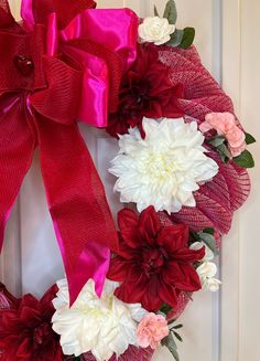 a red and white wreath with flowers on it