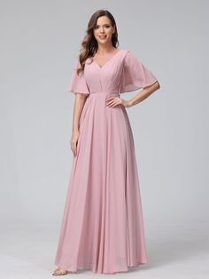 a woman wearing a long pink bridesmaid dress with flutter sleeves and pleaed skirt