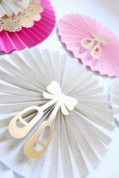 paper fans with gold letters and bows on them are arranged next to each other in different colors