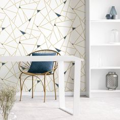 a white table and chair in front of a wall with geometric designs on the walls