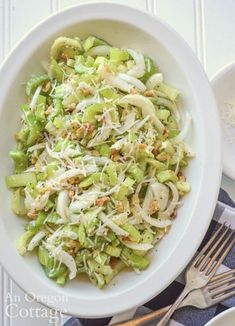 a white bowl filled with coleslaw and sprouts on top of a table