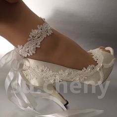 a woman's white wedding shoes with lace and satin ribbons on the heel,