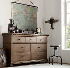 an old dresser with a world map on the wall