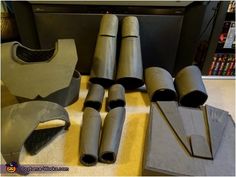 several pieces of metal sitting on top of a yellow cloth covered floor next to a book shelf