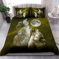 two wolfs are looking up at the moon in this bedding set that is on display