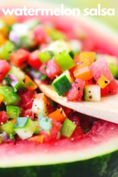 a watermelon salad is shown with a wooden spoon