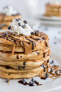 a stack of pancakes topped with chocolate chips and whipped cream