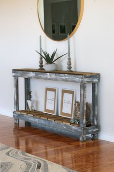 a wooden shelf with two pictures on it in front of a mirror and a rug