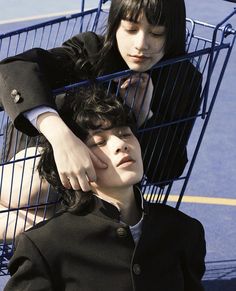 two people sitting in a shopping cart with their hands on each other's head