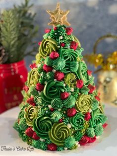 a christmas tree made out of green and red spirals on a white plate next to other holiday decorations