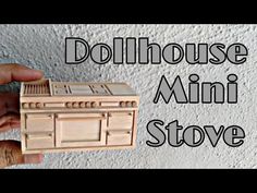 a hand holding a small wooden stove with the words dollhouse mini stove above it