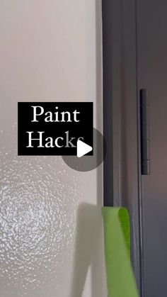 the paint hacker is hanging on the wall next to an open door with a green handle