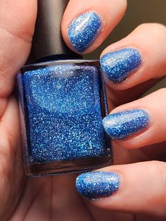 "Once in a Blue Moon is a 16.5 ml blue holo reflective glitter polish. The inspiration for this polish comes from the the winter moon that seems to happen only \"Once in a Blue Moon.\" Perfect for the winter season, but it would be lovely year-round.  Mostly opaque in 2-3 coats. To see the reflective glitter, shine a flashlight or use a flash from a cell phone. Refective polishes tend to have a grainy texture and are a tad bit harder to use than typical nail polishes as it becomes gloopy. Use nail polish thinner to make it easier to use. This polish will dry with texture due to the large amount of reflective glitter. You can negate this with a coat or two of a top coat. I also recommend a glitter smoother before the top coat. Due to various monitor settings and the homemade nature of this Navy Blue Shimmer Nails, Dark Blue Holographic Nails, Metallic Blue Nail Polish, Reflective Nails, Winter Moon, Polyethylene Terephthalate, Iron Oxide, Blue Moon, Flashlight