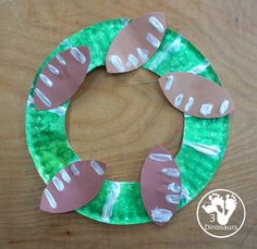 a paper plate wreath made to look like a handprinted christmas ornament