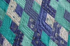 a blue and green quilt is on display