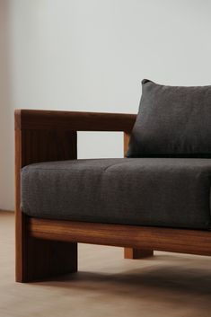 a wooden chair with black cushions on it