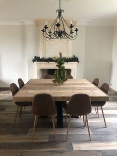 a dining room table with six chairs and a chandelier hanging from the ceiling