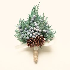 a bouquet of pine cones and evergreen needles on a white ribbon tied to a piece of paper