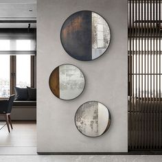 three circular mirrors mounted to the side of a wall next to a dining room table