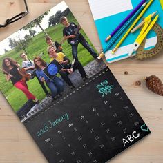 a calendar with photos on it next to some pencils