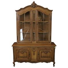 an old fashioned china cabinet with glass doors