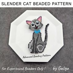 a black and white cat beaded pattern sitting on top of a plate with the words se