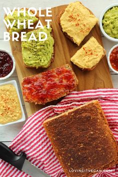 some food is laying out on a cutting board with sauces and bread in bowls