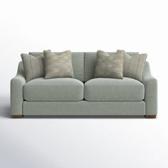 a light green couch with pillows on it